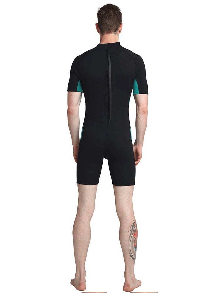 Man wearing short-sleeved black and teal snorkeling and surfing wetsuit, showing back view with tattoo visible on leg.